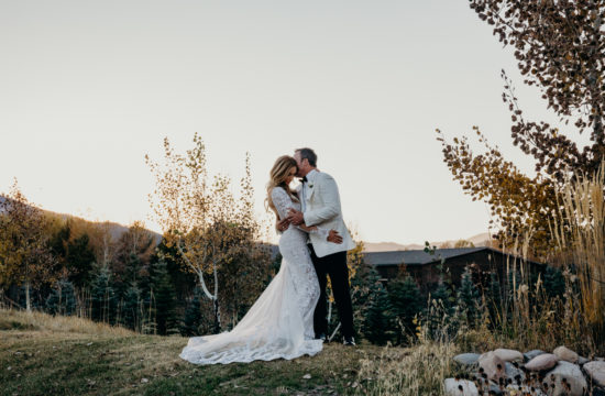 Couple embrace on a hillside during sunset at their Jackson Hole wedding