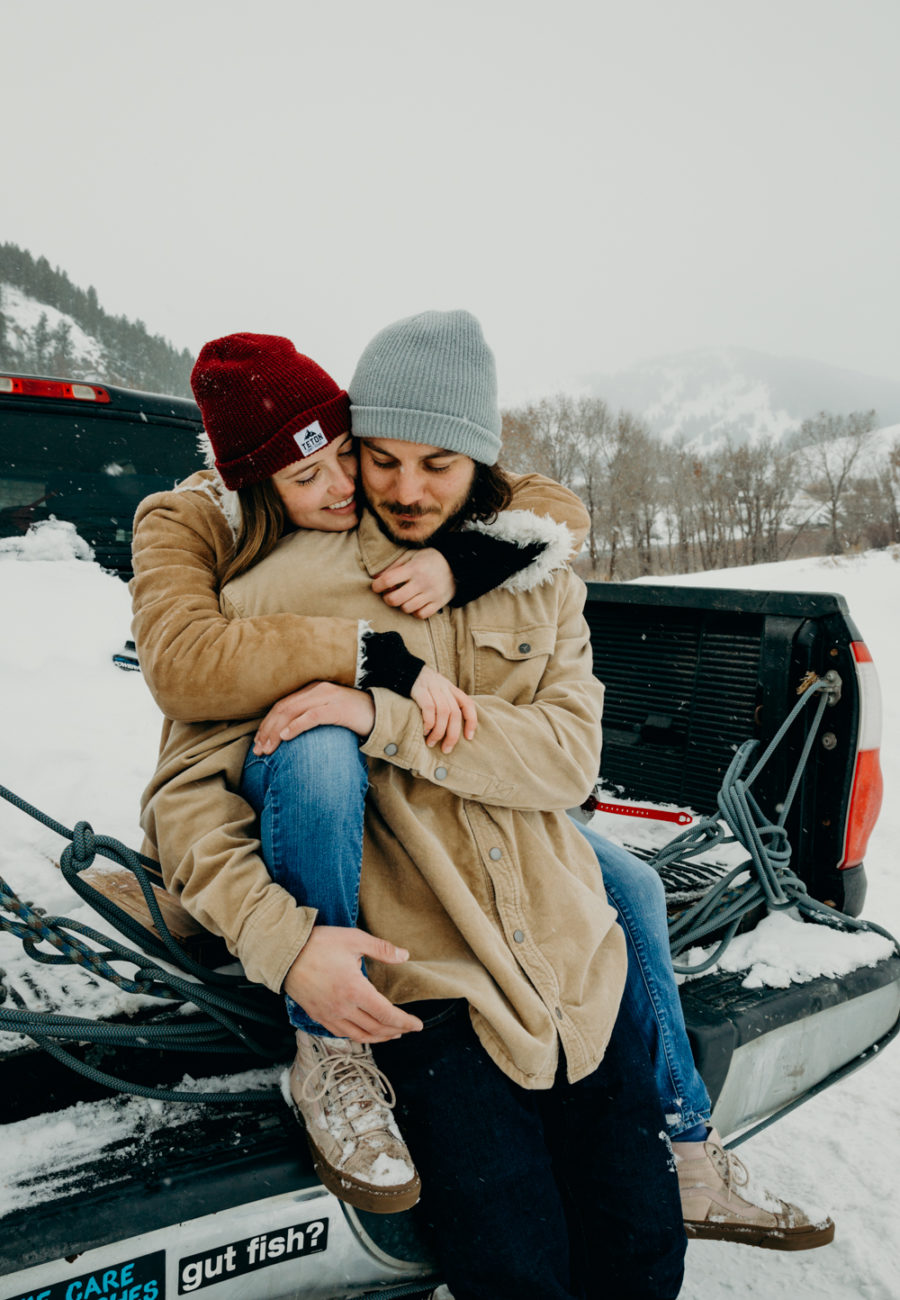 A couple sits on the back of a pickup truck together in Jackson Hole, Wyoming