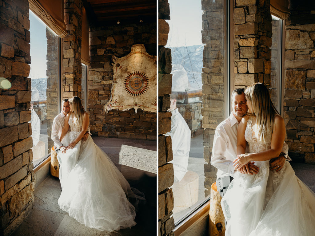 Couple sit on a tree round inside together during wedding at Amangani resort in Jackson Hole Wyoming at sunset